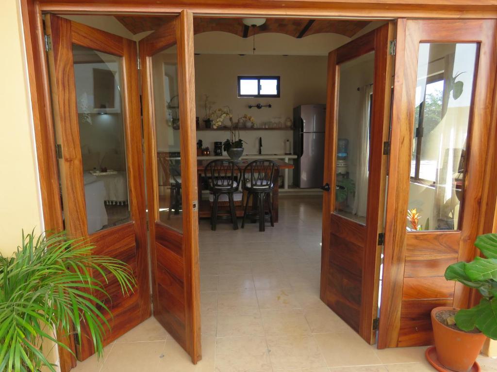a kitchen and dining room with wooden doors and a table at Casa Botanica in Lo de Marcos