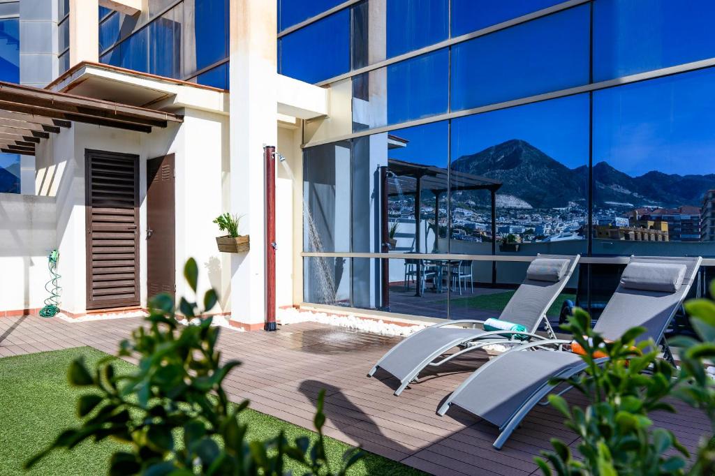 balcón con sillas y vistas a las montañas en Apartamento Dúplex Solárium Benalmádena Playa, en Benalmádena