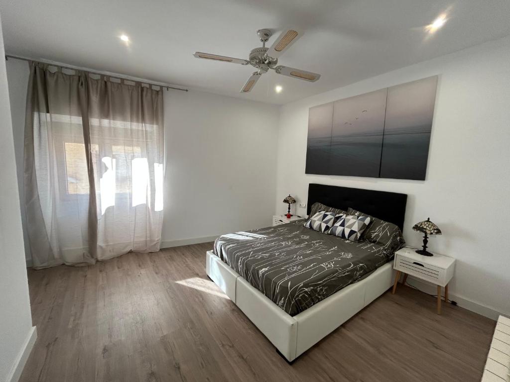 Schlafzimmer mit einem Bett und einem Deckenventilator in der Unterkunft Costa Brava Apartments in Palafrugell