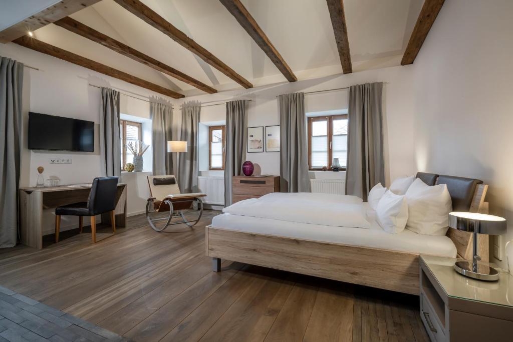 1 dormitorio con 1 cama blanca grande y escritorio en Gasthaus Unterwirt en Fridolfing