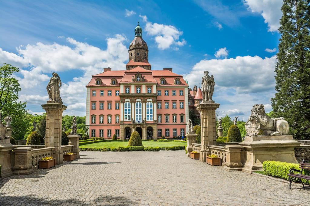 duży różowy budynek z posągami przed nim w obiekcie Hotel Przy Oślej Bramie - Zamek Książ w Wałbrzychu