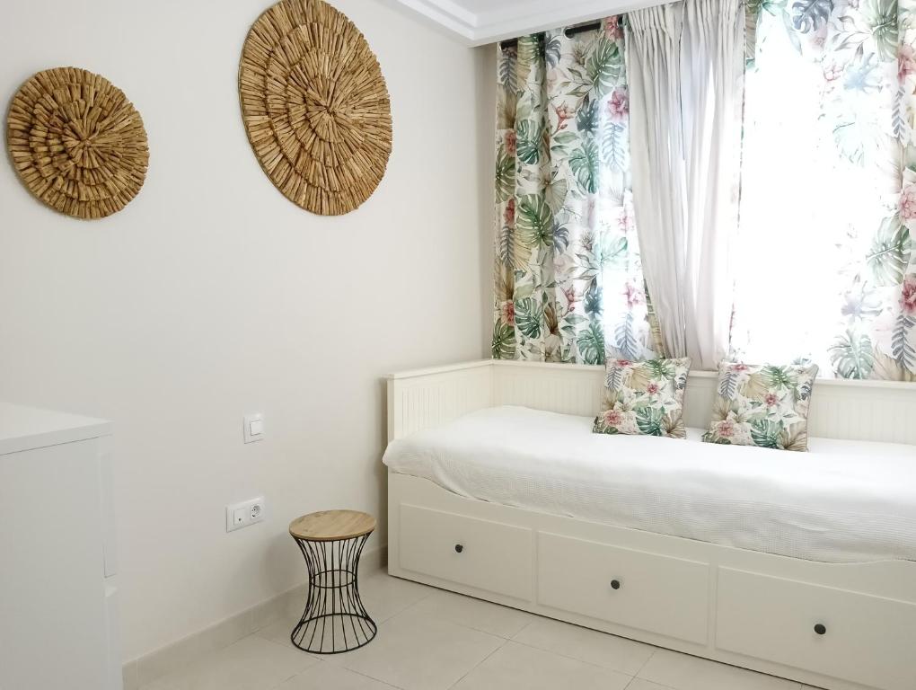 a bedroom with a bed with a window and a stool at Paula Pool Apartment Adeje in Adeje