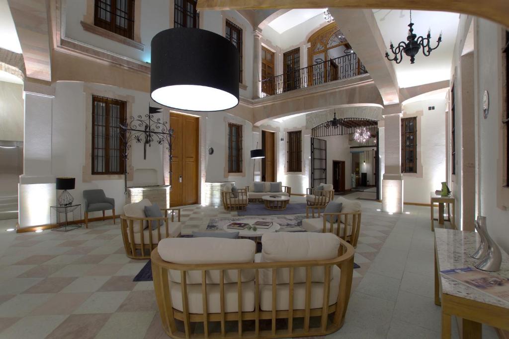 een grote woonkamer met een tafel en stoelen bij Nueve 25 Hotel Boutique in Guanajuato