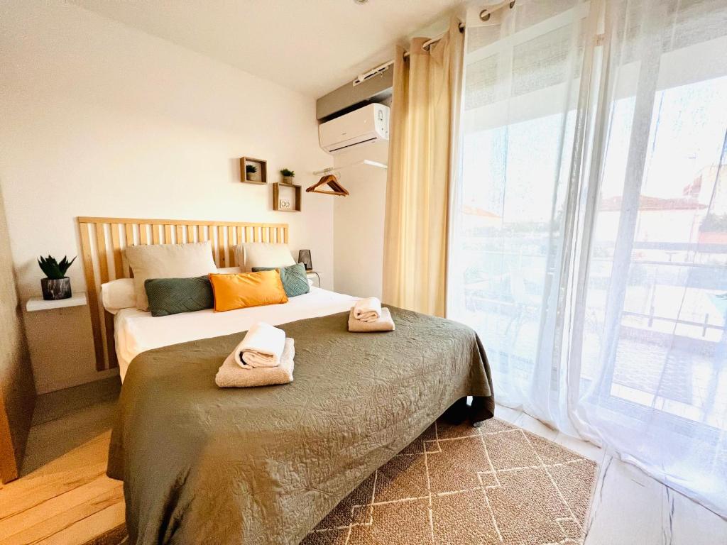 une chambre avec un lit avec des serviettes dessus dans l'établissement LES PALMIERS - Appartement avec piscine proche plages - Wifi et Clim, à Antibes