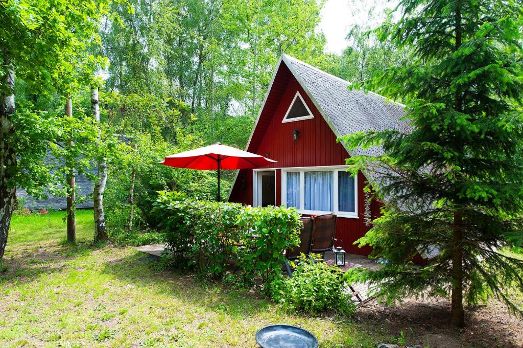 ein rotes Haus mit einem roten Regenschirm davor in der Unterkunft Ferienhaus Katharina in Malschwitz