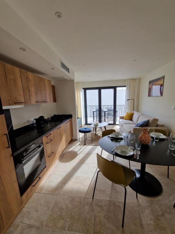 une cuisine et un salon avec une table et un canapé dans l'établissement Les Papillos du Ventoux - Le Petit Sylvain - één slaapkamer met terras, à Malaucène