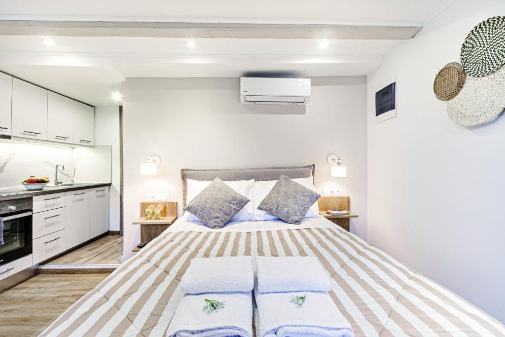 1 dormitorio con 1 cama grande con almohadas azules en Ionian Citizen Atelier, en Corfú