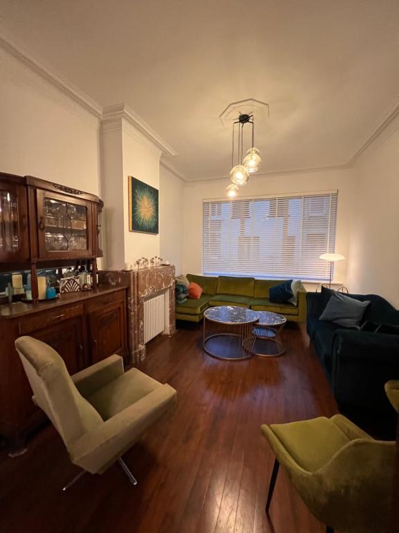 a living room with a couch and a table at Charmante Art Deco rijwoning in Ostend