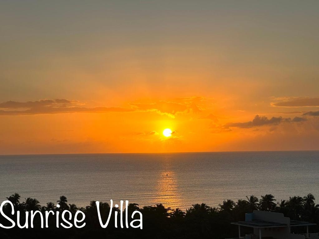 a sunset over the ocean with the sun in the sky at Sunrise Villa in Maunabo