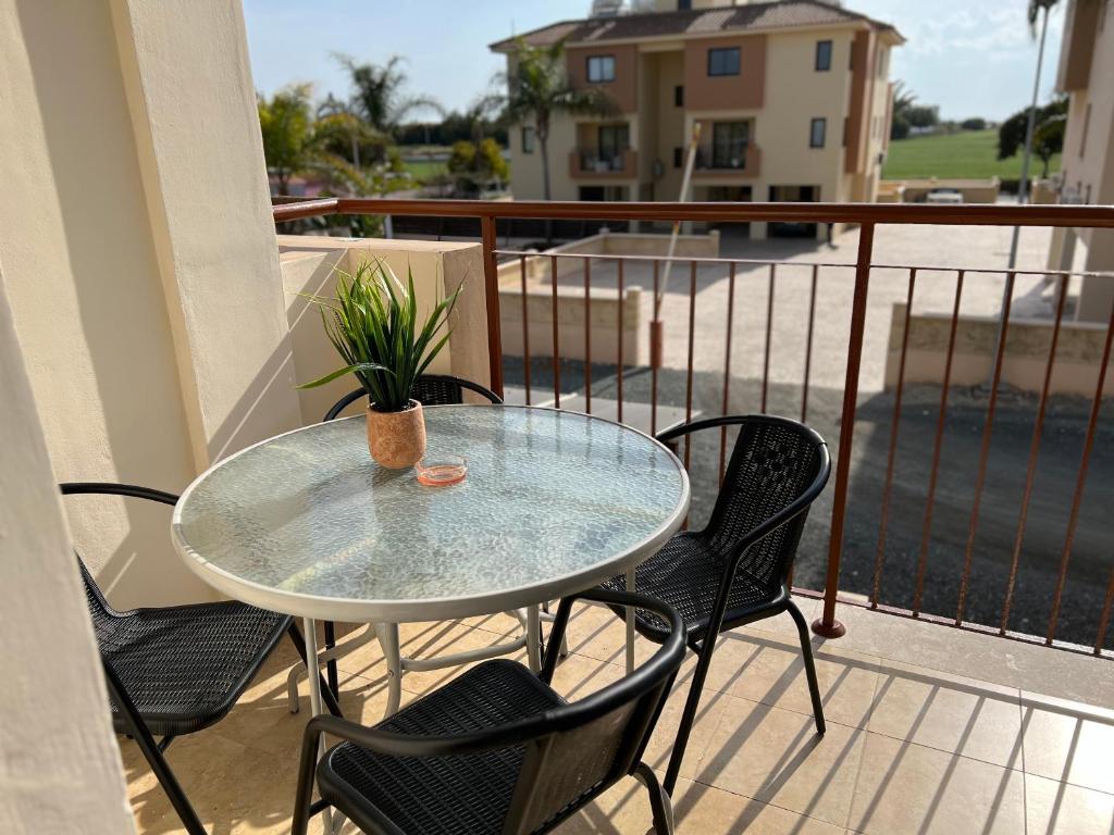 a glass table and chairs on a balcony at AFRODITI APARTMENTs in Perivolia