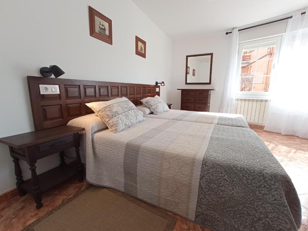Schlafzimmer mit einem Bett, einem Tisch und einem Fenster in der Unterkunft EL RINCON DE LUISA Y SANTOS in Ezcaray
