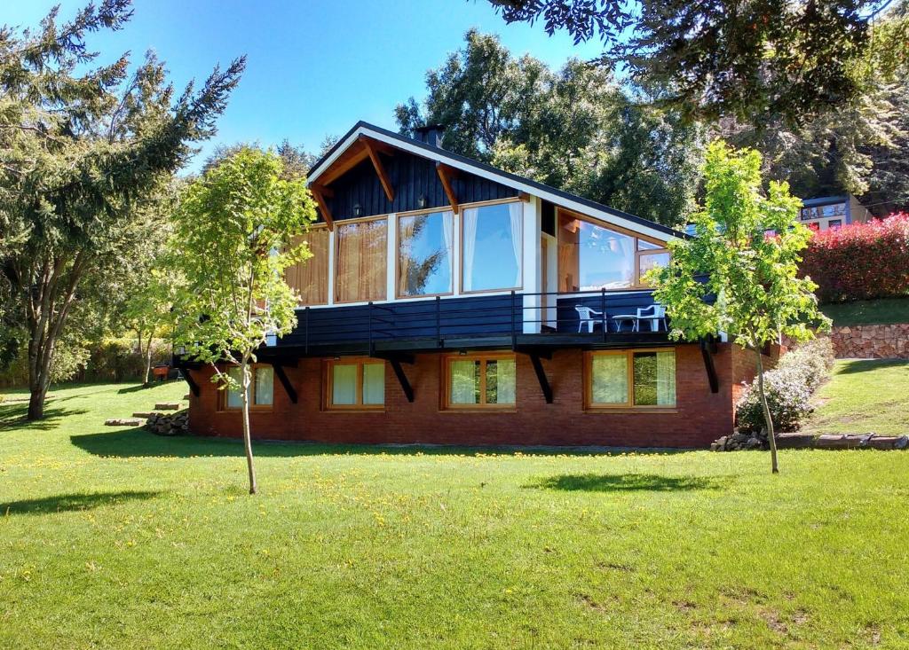 een groot huis met een balkon op een tuin bij Cabañas Carelmapu in Bariloche
