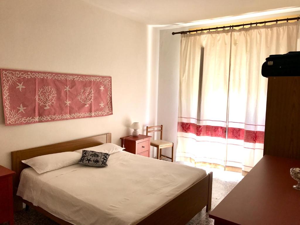 um pequeno quarto com uma cama e uma janela em Casa in centro a due passi dal mare em Santa Teresa Gallura