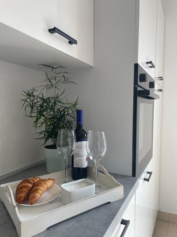 ein Tablett mit einer Flasche Wein und Weingläsern in der Unterkunft Apartment Seaside Orebić in Orebić