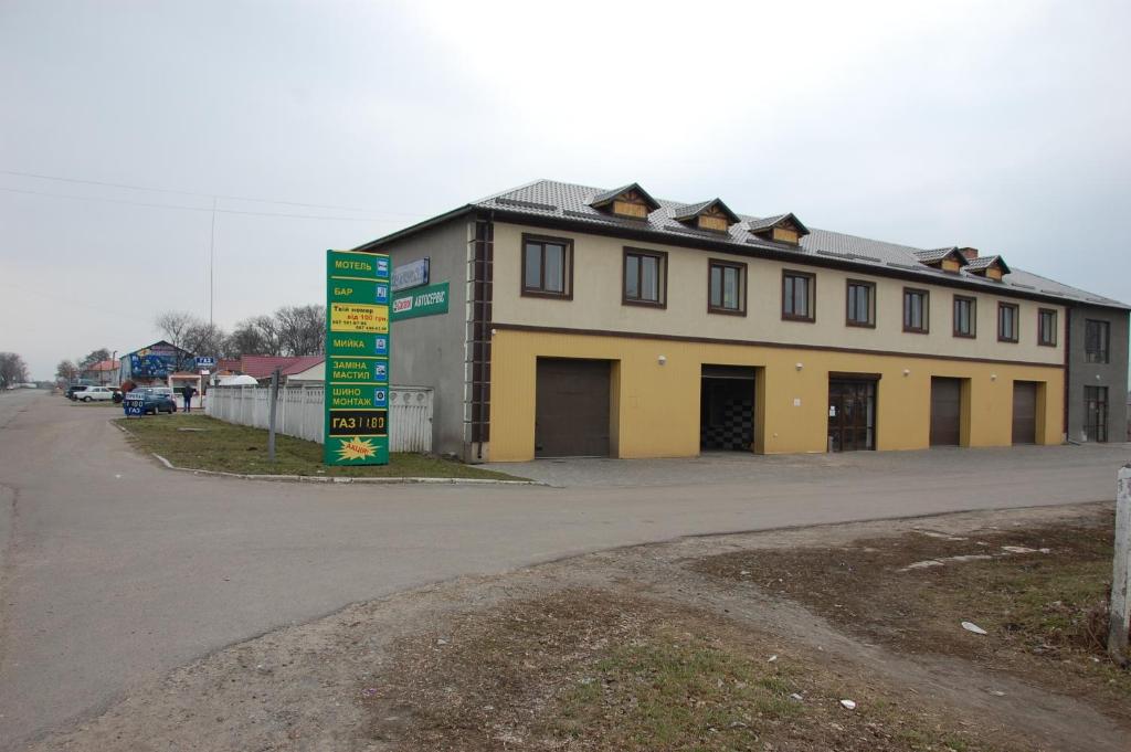 um grande edifício amarelo no lado de uma estrada em Dalekobiynyk em Uzyn