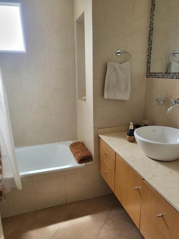 y baño con bañera blanca y lavamanos. en Depto 2 ambientes super luminoso en Buenos Aires