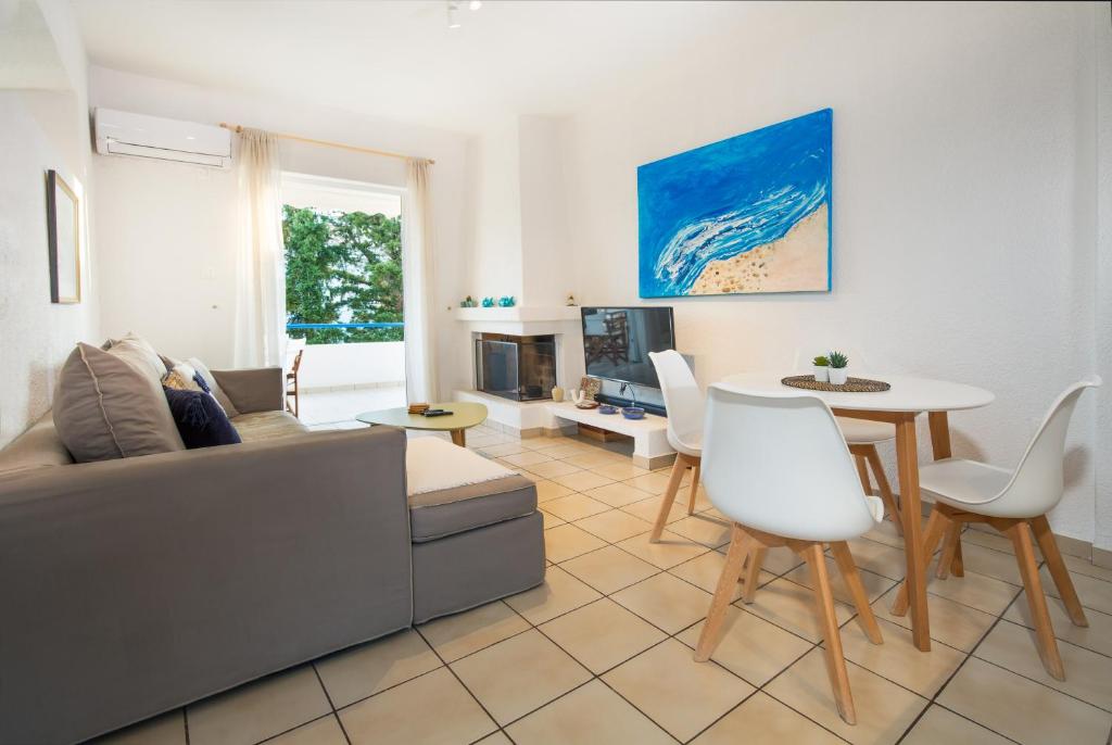 un soggiorno con divano e tavolo di Del Mar Luxury Apartment 30m From The Beach a Porto Rafti