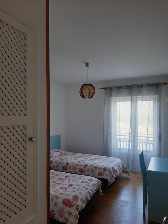 um quarto com duas camas e uma janela em Apartamento da Praia em Odeceixe