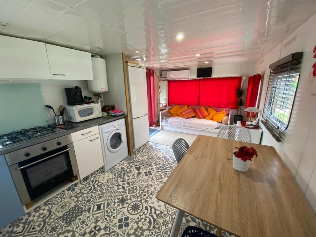 a kitchen and living room with a table in a trailer at Chalet de Provence in Aix-en-Provence