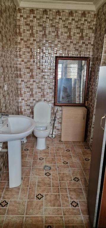 uma casa de banho com um WC, um lavatório e uma janela em OKF OBOUBA APARTMENT em Kumasi