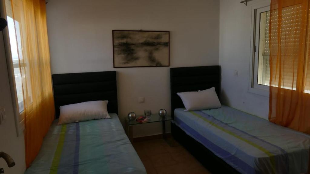 a bedroom with two beds and a window at Apartment Amira Smir in Riffiene