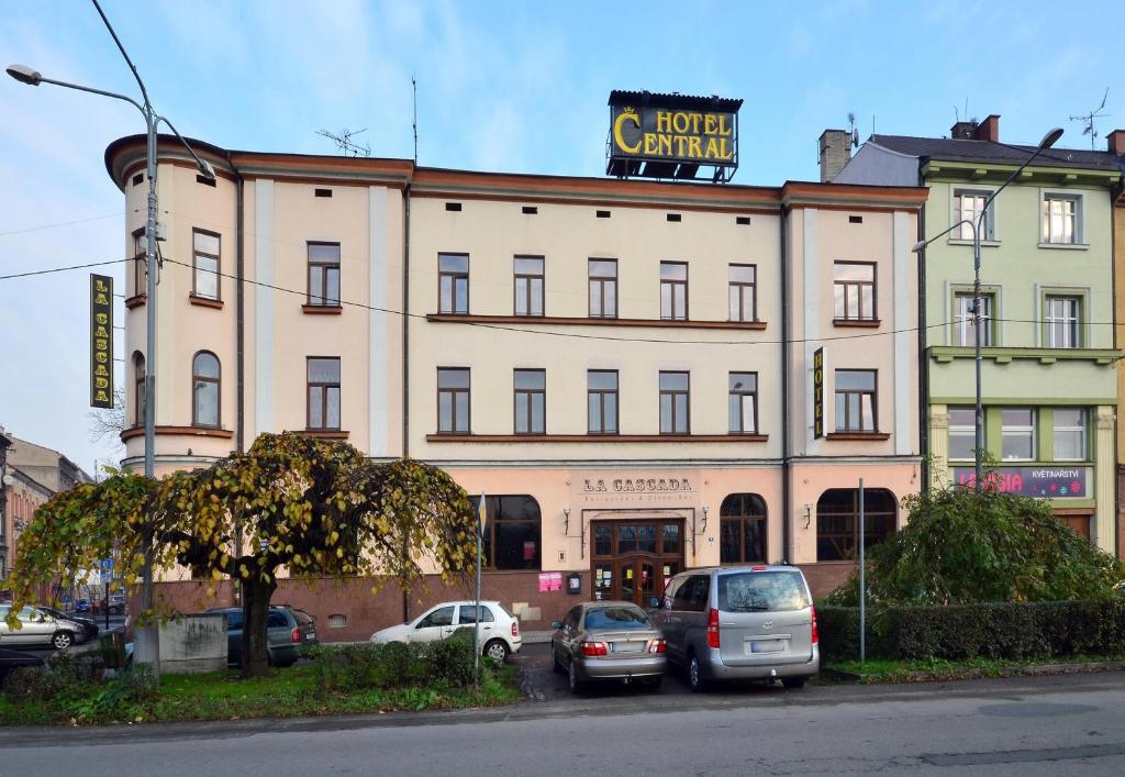 duży budynek z samochodami zaparkowanymi przed nim w obiekcie Hotel Central w Czeskim Cieszynie