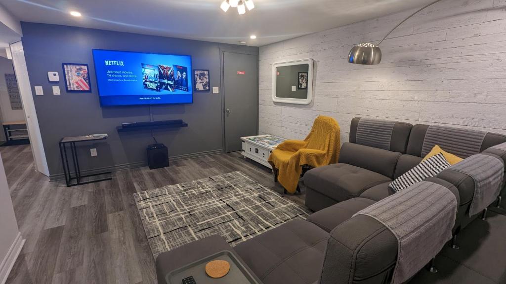 a living room with a couch and a flat screen tv at Simplement l’Harmonie à Chambly in Chambly