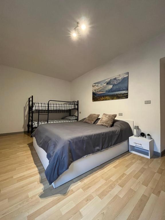 a bedroom with a large bed and a wooden floor at Appartamenti Le Calle in Nago-Torbole
