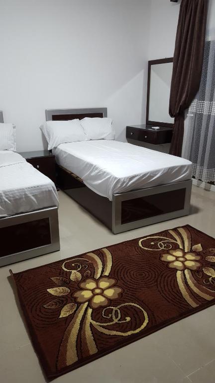 sypialnia z 2 łóżkami i dywanem na podłodze w obiekcie Half Moon - Sunny Dahab resort w mieście Dahab