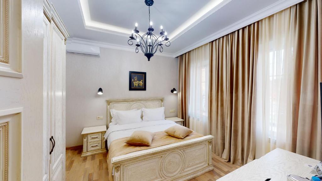 1 dormitorio con cama y lámpara de araña en Aspar Boutique Hotel en Ereván