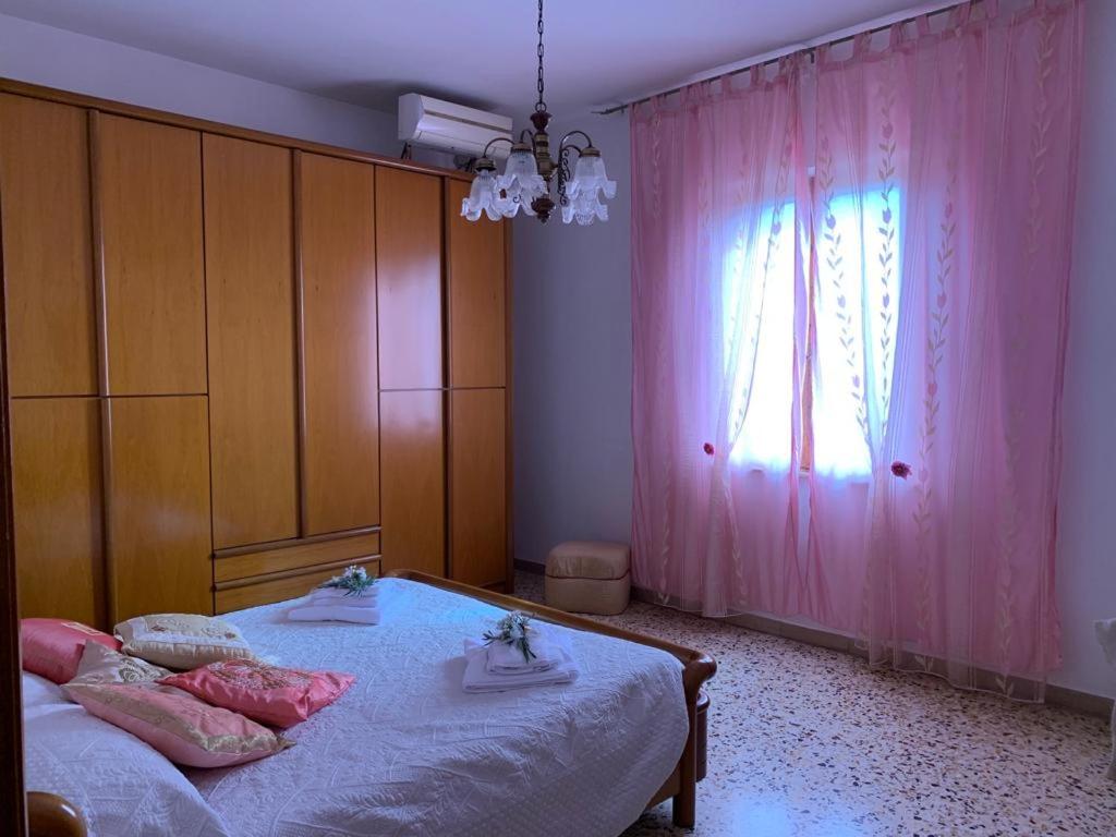 a bedroom with two beds and a pink curtain at Nonna Nesti in Cortona