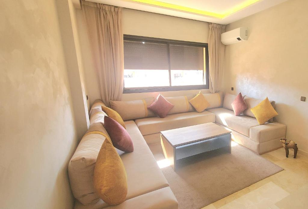 een woonkamer met een bank en een raam bij Appartement tout neuf en plein centre de Marrakech in Marrakesh