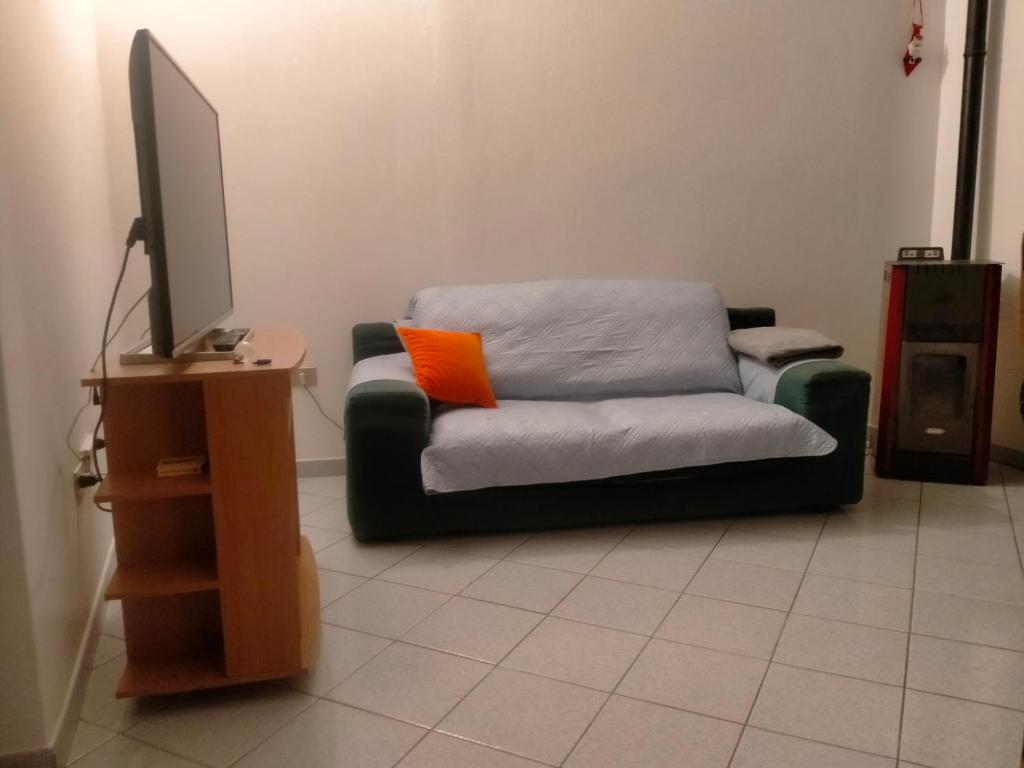 un sofá en una sala de estar con TV en Appartamento Santa Giusta, en Santa Giusta