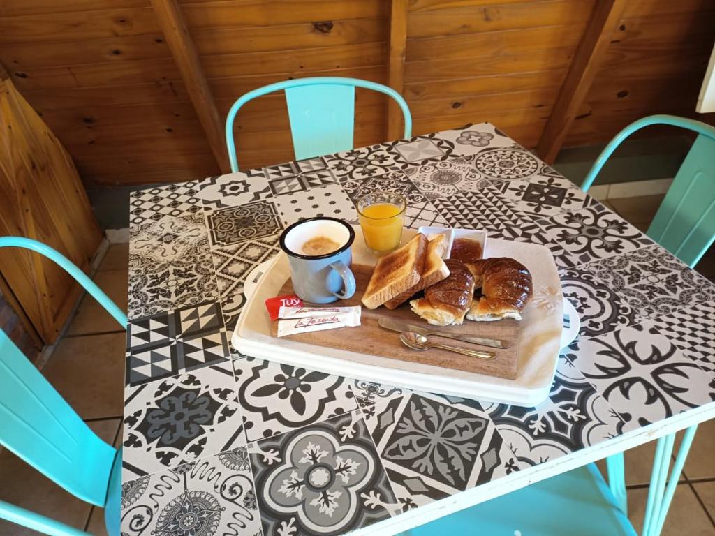 a table with a tray of pastries and a cup of coffee at Quedate Apart Hotel in Correa
