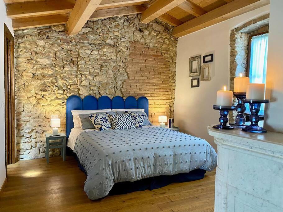Un dormitorio con una cama azul y una pared de piedra en Sally's House en San Gemini