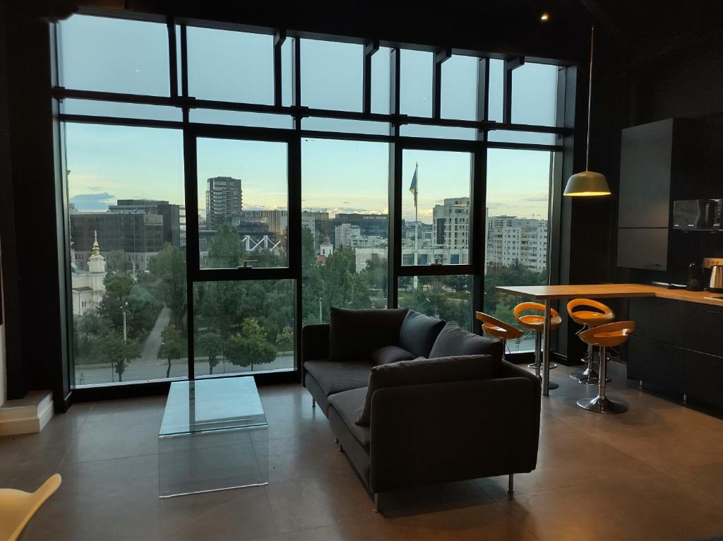 a living room with a couch and a large window at Sky Loft in Iaşi