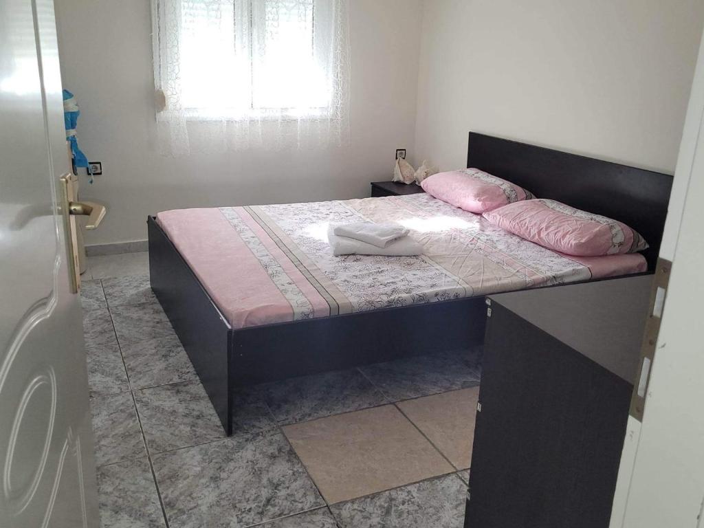 ein Schlafzimmer mit einem Bett mit rosa Kissen darauf in der Unterkunft Narcis House in Thessaloniki