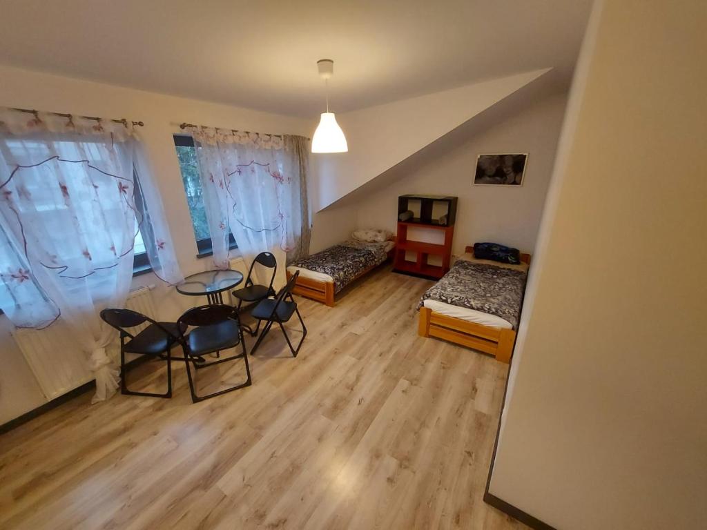 Habitación con 2 camas, mesa y sillas en Galeria kolorów pokój 4 osobowy en Lodz