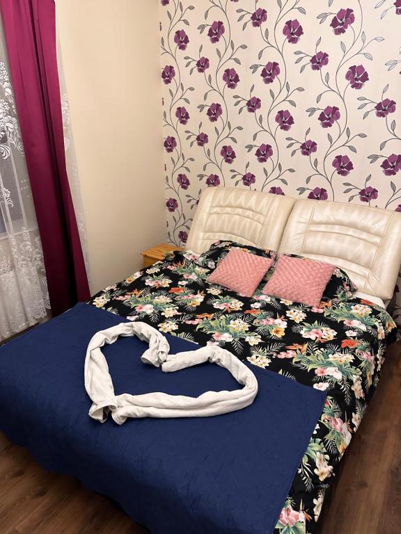 1 cama con edredón azul y pared de flores en BIG BED JACUZZI, PRIVATE SAUNA AND CINEMA, en Dobrzewino