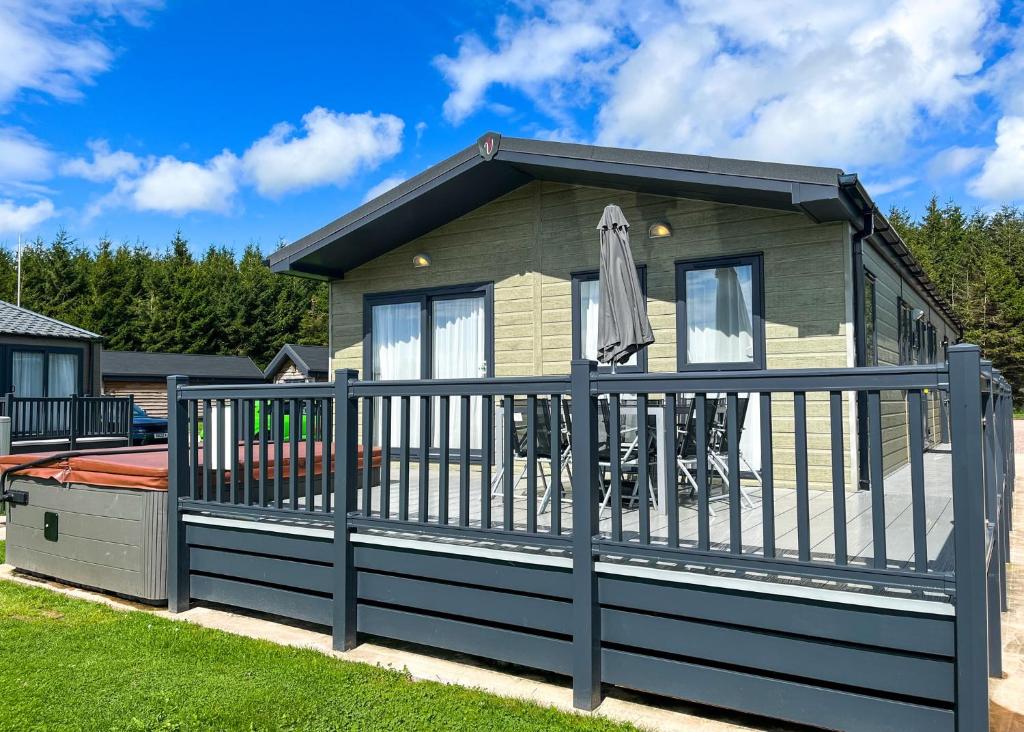 a small house with a fence around it at Westlands Country Park in Annan