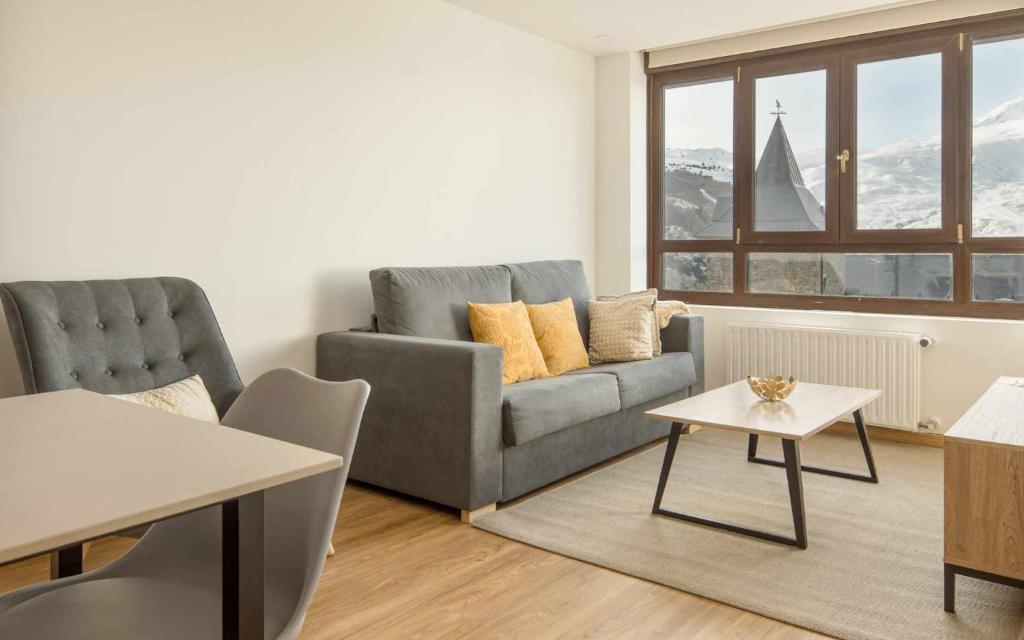 a living room with a couch and a table at Apartamento Elurra Formigal in Formigal