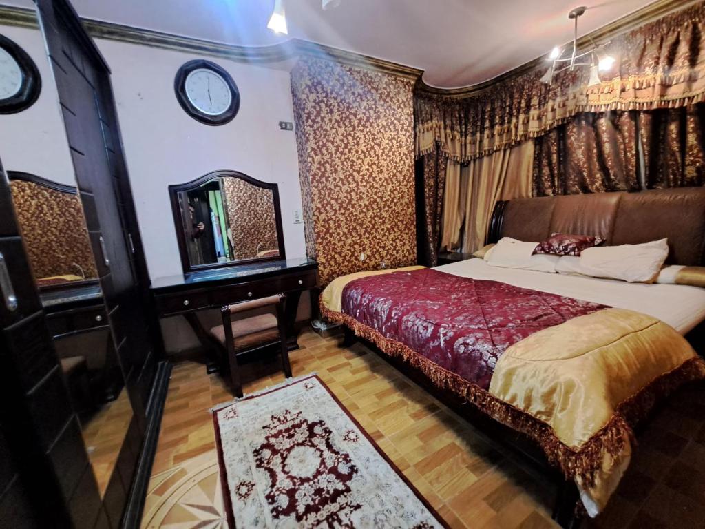 een slaapkamer met een bed, een dressoir en een spiegel bij Hijaz Square Hotel in Caïro