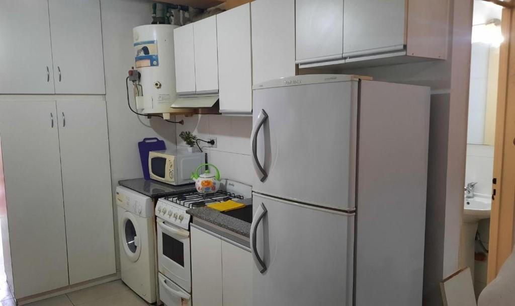 La cuisine est équipée de placards blancs et d'un réfrigérateur blanc. dans l'établissement Departamento Citrino, à Godoy Cruz