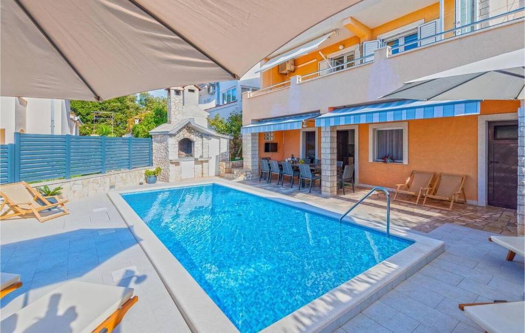 a swimming pool in front of a house at Vacation house with heated swimming pool 70 meters from the beach-Bobanac in Ražanj