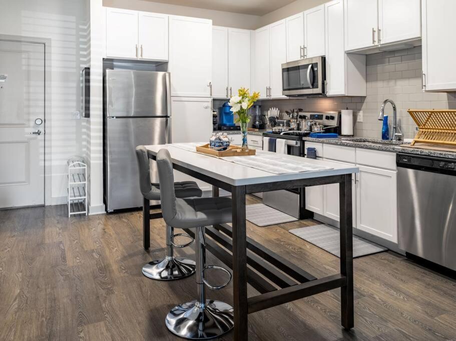 eine Küche mit einem Tisch mit Stühlen und einem Kühlschrank in der Unterkunft Ideal Modern Retreat in Jacksonville