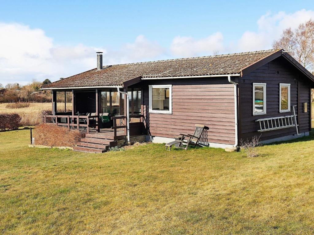 ein kleines Haus mit einer Veranda und einem Grasfeld in der Unterkunft Holiday home Vordingborg X in Vordingborg