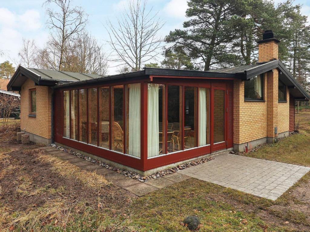 ein Haus mit einer abgeschirmten Veranda in der Unterkunft 6 person holiday home in Væggerløse-By Traum in Bøtø By