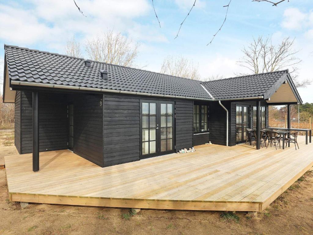 una casa negra con terraza y mesa en 6 person holiday home in Martofte-By Traum, en Martofte