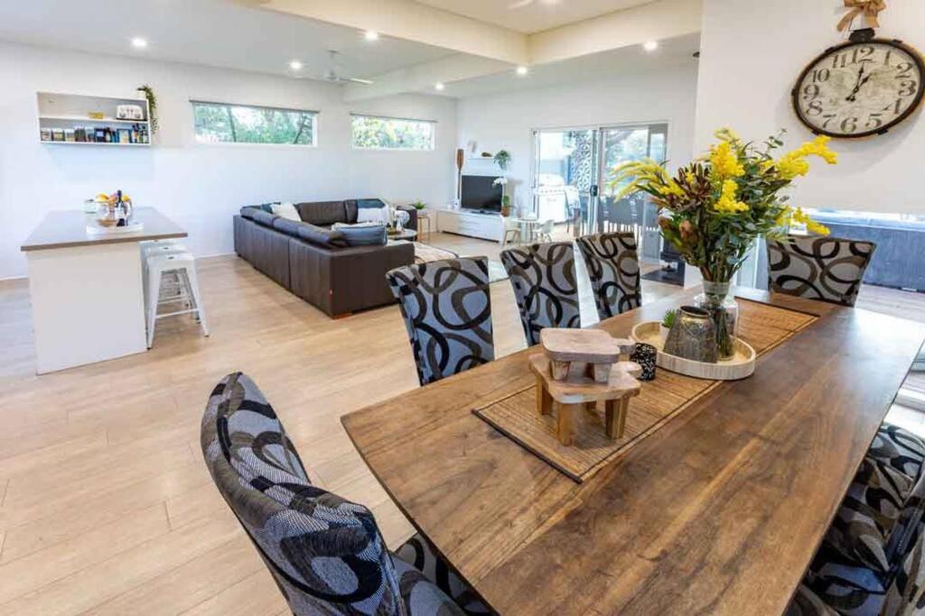 una sala de estar con una gran mesa de madera y sillas en Pandora Beach House en Venus Bay