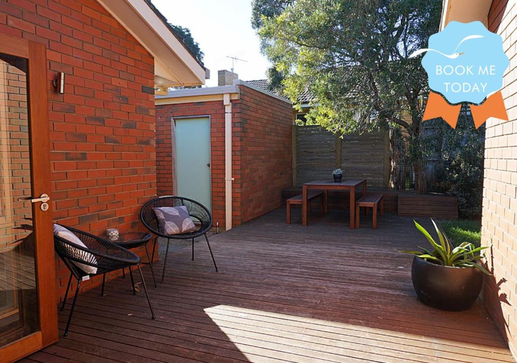 a patio with a table and chairs and a brick wall at Tussock Sands in Point Lonsdale